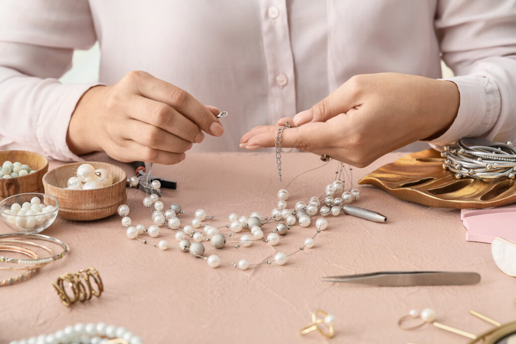 Female designer making jewelry at workplace