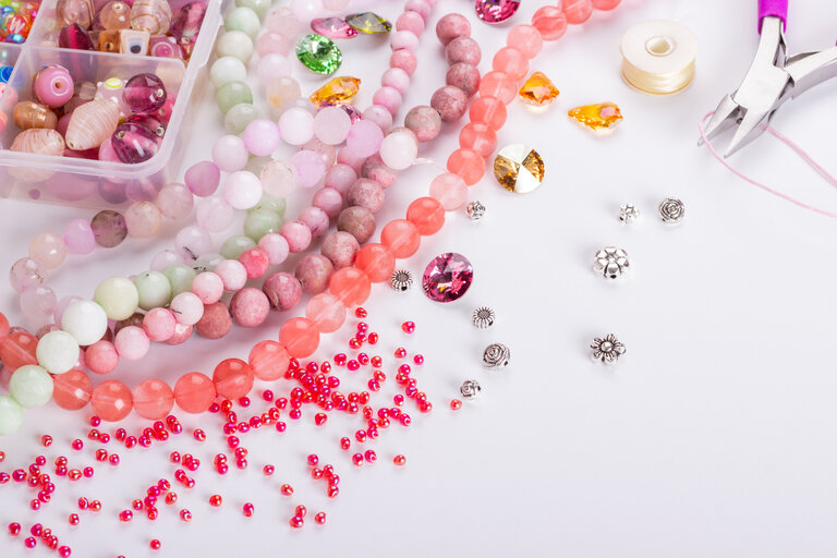 Rose cherry pink quartz stone beads on white background closeup. Selective focus.